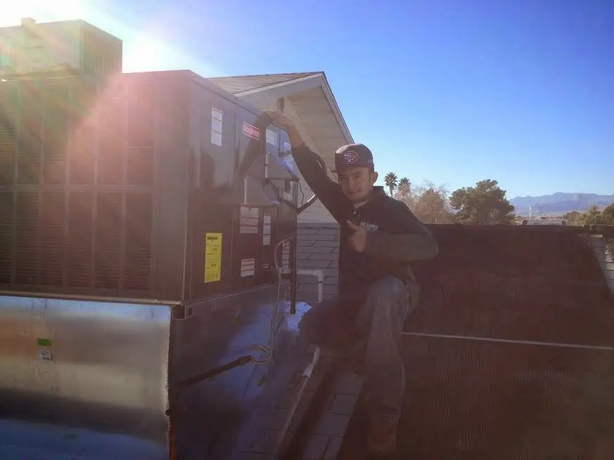 HVAC technician performing Heat Pump Repair on a rooftop unit in McMinnville